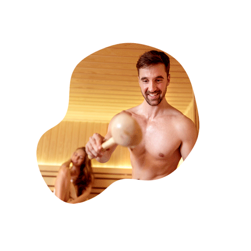 Ein Pärchen genießt den Saunagang, während der Mann den Aufguss macht